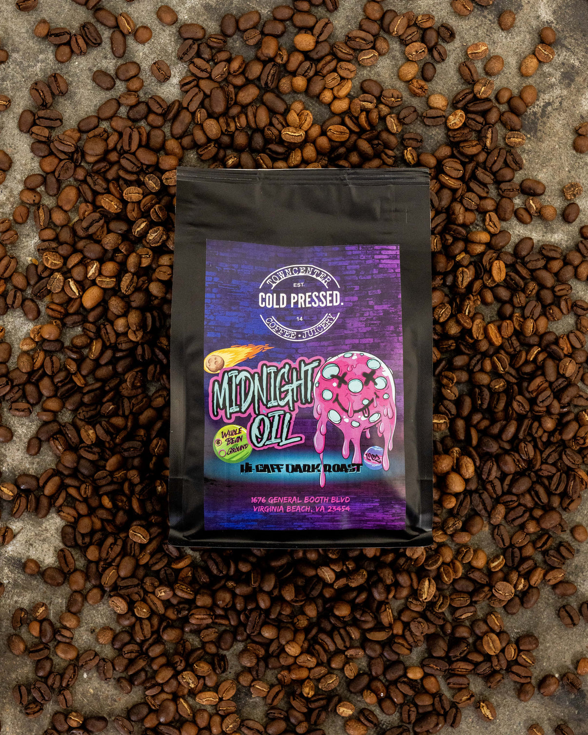 Coffee package labeled 'Midnight Oil' surrounded by coffee beans on a textured surface